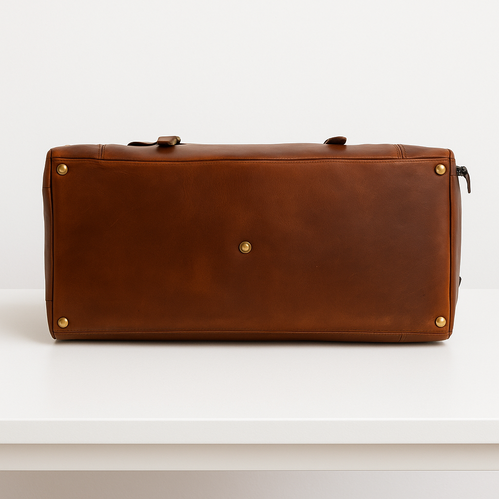 Bottom view of brown leather cowhide duffle bag with gold metal feet