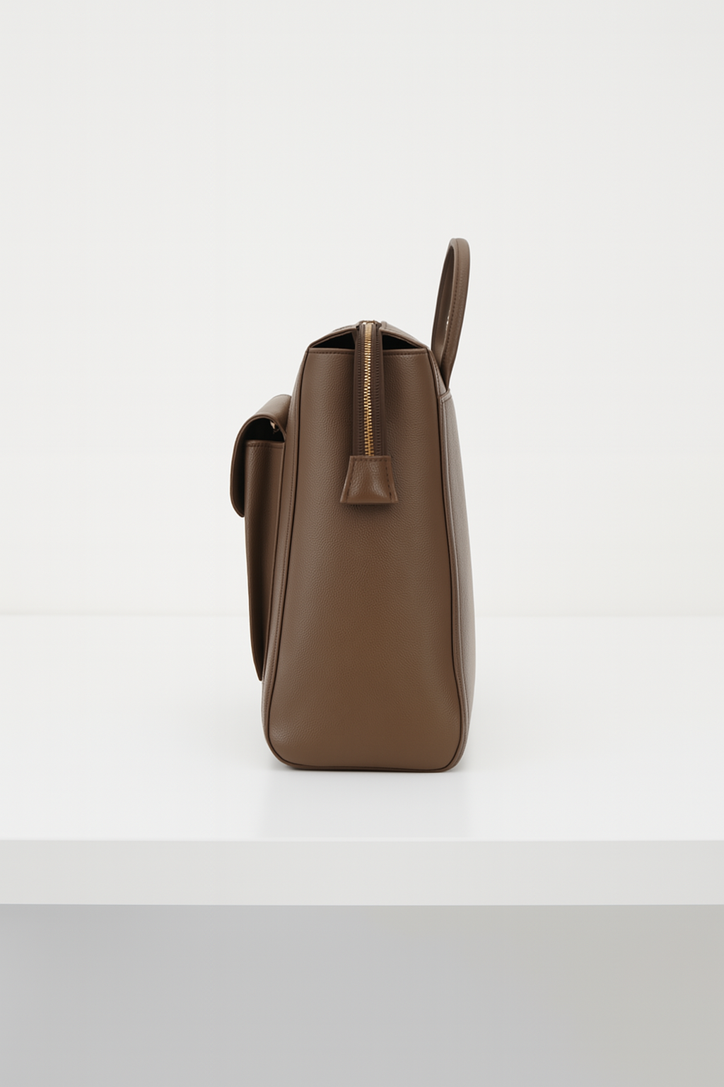 Side view of brown convertible leather backpack with top zipper closure.